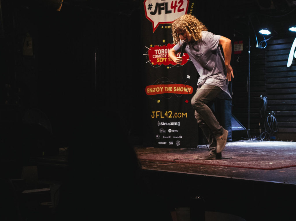 A comedian performing standup in a comedy bar